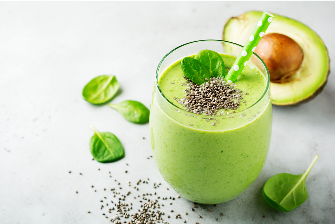 Vegetarian healthy green smoothie from avocado, spinach leaves and chia seeds on gray concrete background