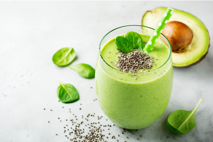 Vegetarian healthy green smoothie from avocado, spinach leaves and chia seeds on gray concrete background