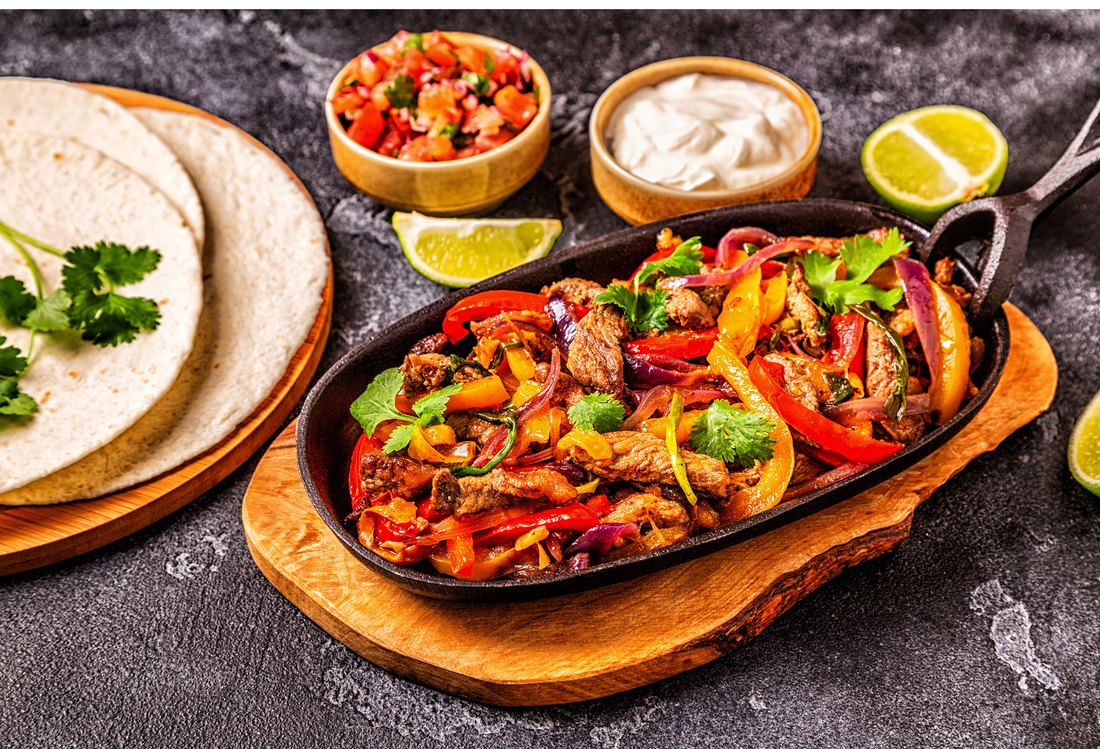 FAJITAS with colored pepper and onions, served with tortillas, salsa and sour cream