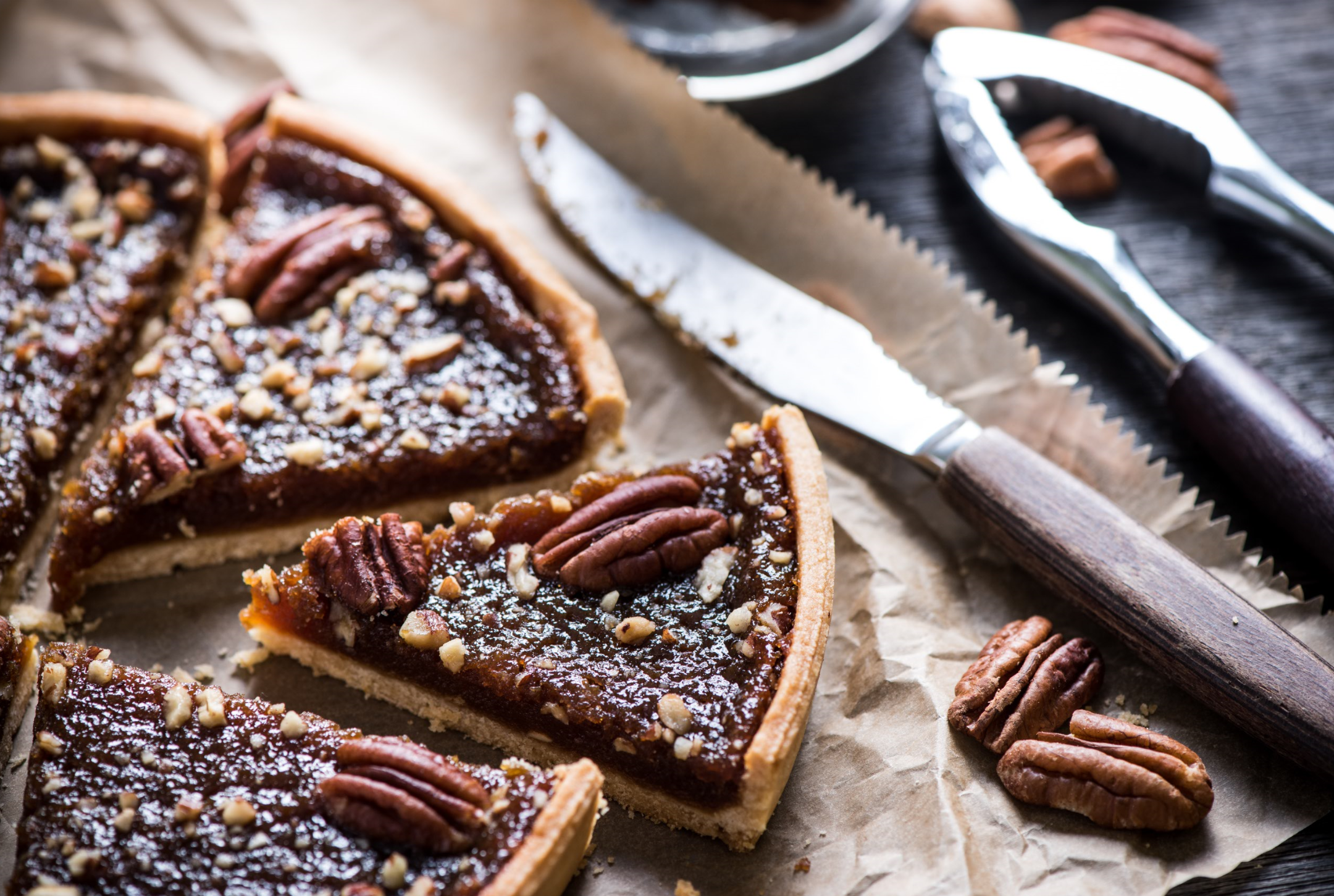 chocolate pecan pie cut into slices on parchment paper