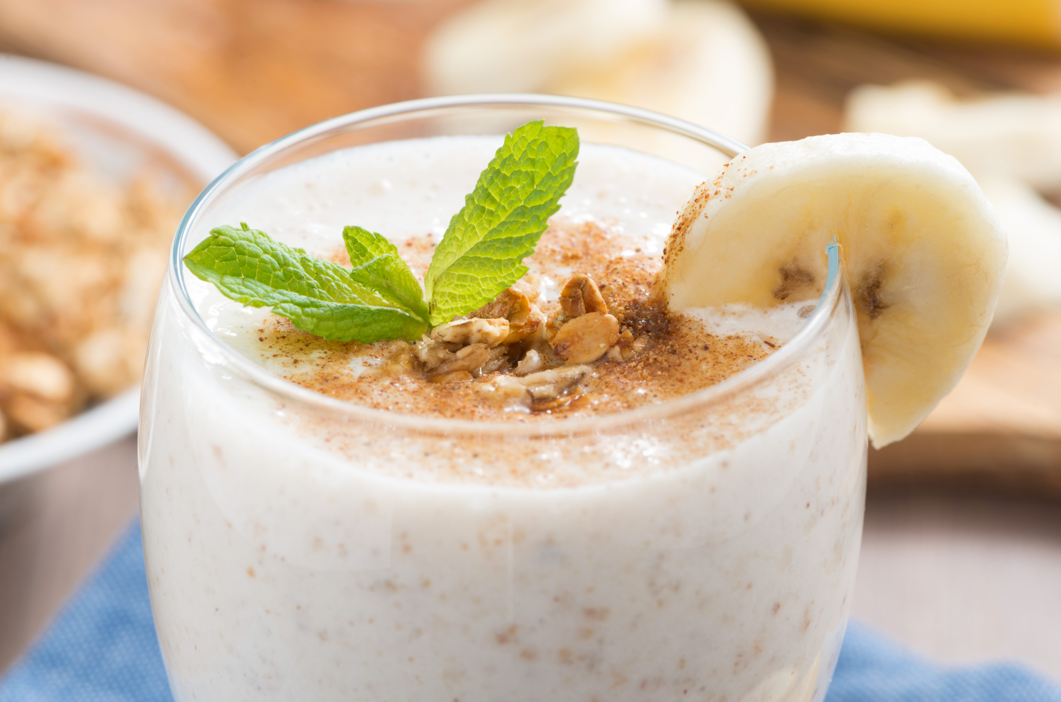 milkshake with banana, granola and cinnamon in a glass, close-up, horizontal