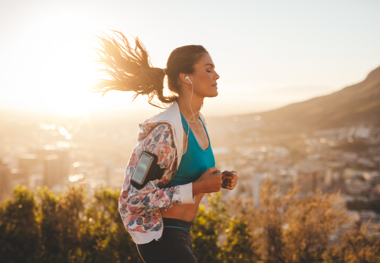  female model jogging outdoors with headphones