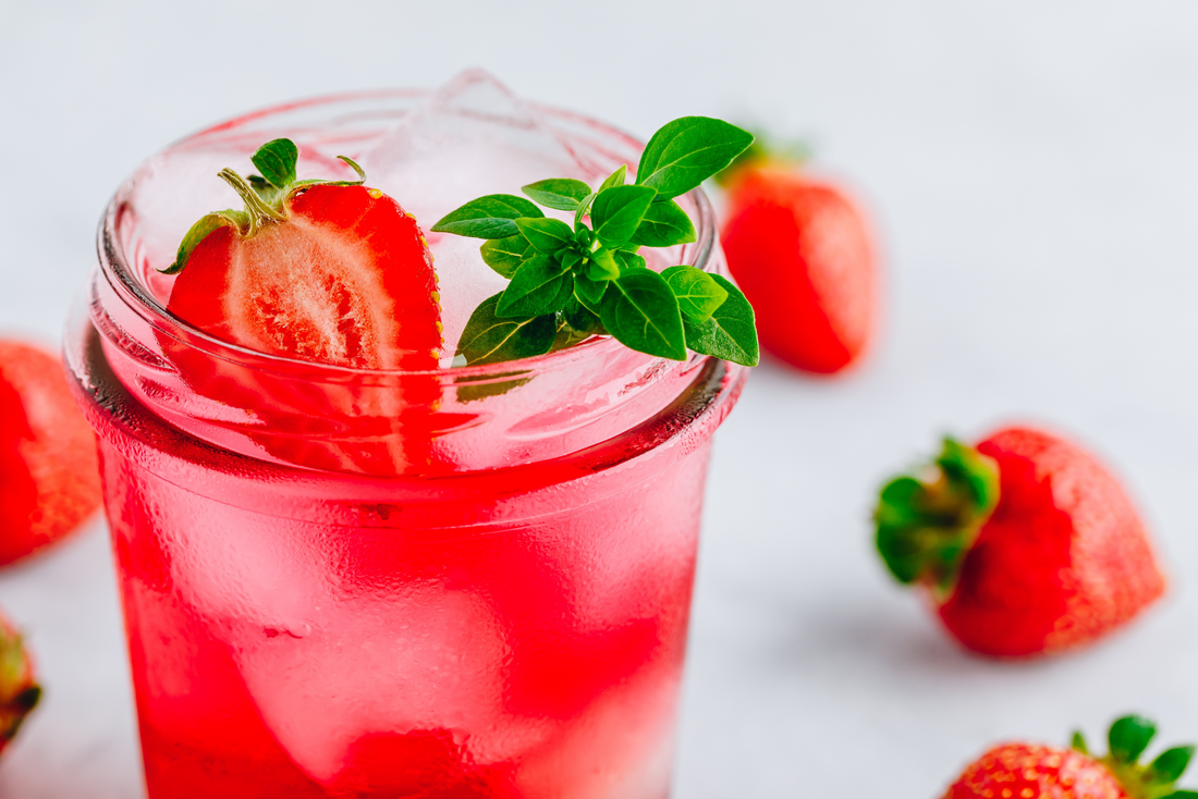 A glass of Strawberry Basil Lemonade and fresh strawberries