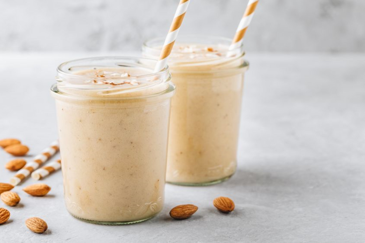vanilla almond smoothie with with almond milk in glass jars with straws