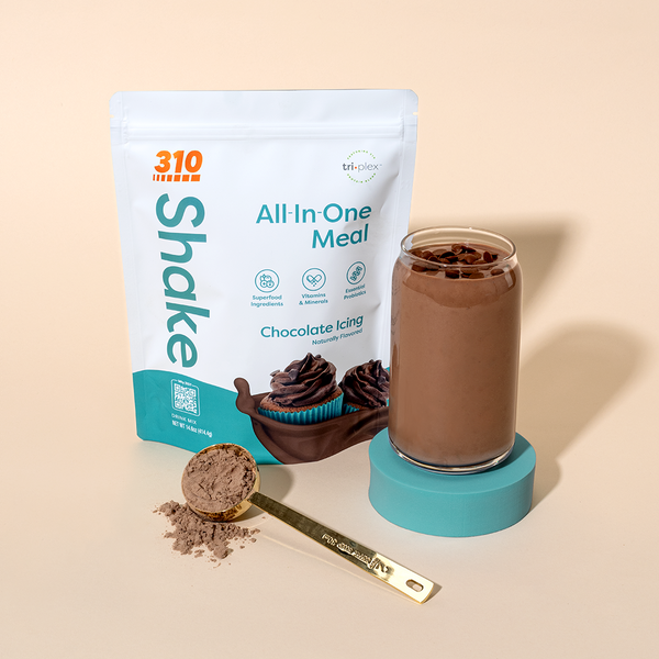 310 Chocolate Icing Shake pack alongside rich chocolate shake and a scoop of protein powder.