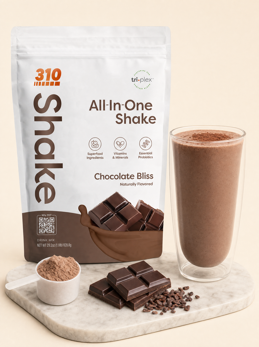 310 All-In-One Shake Chocolate Bliss pouch with a blended chocolate shake, a scoop of powder and dark chocolate