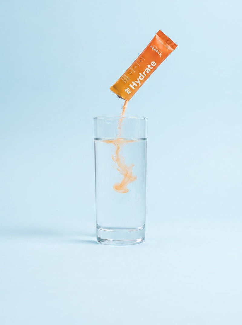 Tangerine powder blooming into a glass of still water