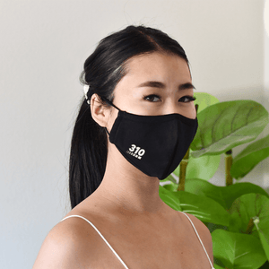 woman in white sleeve less top wearing 310 face mask