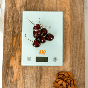 digital scale with fresh cherries on it and a bunch of almond on the side