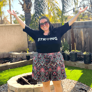 a woman in the backyard wearing strong shirt