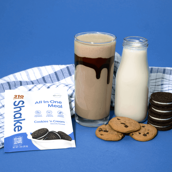 310 cookies n' cream with a glass of shake, a jar of milk, cookies and a striped cloth.