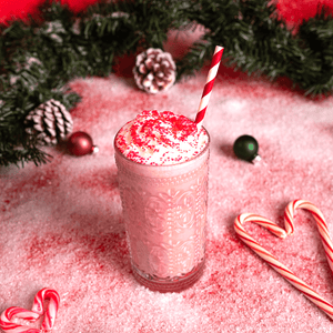 A peppermint swirl shake in a festive-themed setting with heart-shaped candy cane.