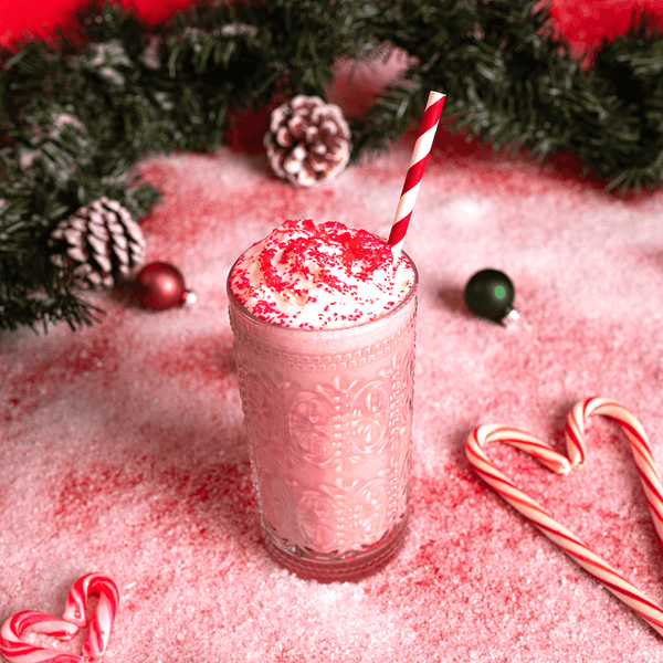 A peppermint swirl shake in a festive-themed setting with heart-shaped candy cane.