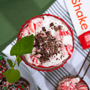 overhead view of peppermint swirl shake topped with candy cane and chocolates.