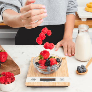 woman weighing a bowl of berries