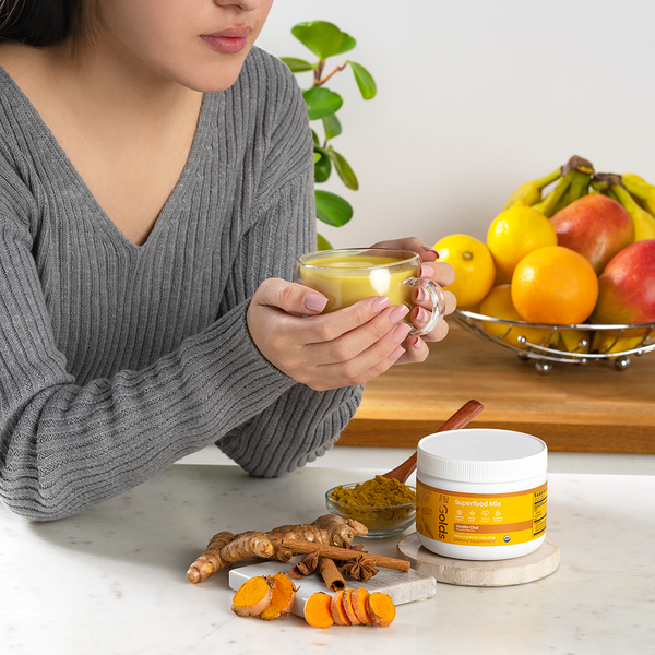 a woman holding a glass of vanilla chai drink