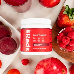 Overhead view of 310 Reds Black Cherry flavor with fresh berries, apples and a glass of juice.