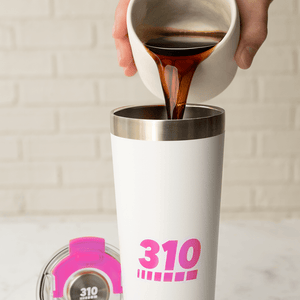 a drink poured on a pink insulated stainless steel travel mug