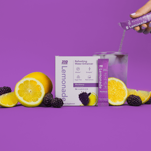 blackberry lemonade box, lemons, blackberry and a glass of water
