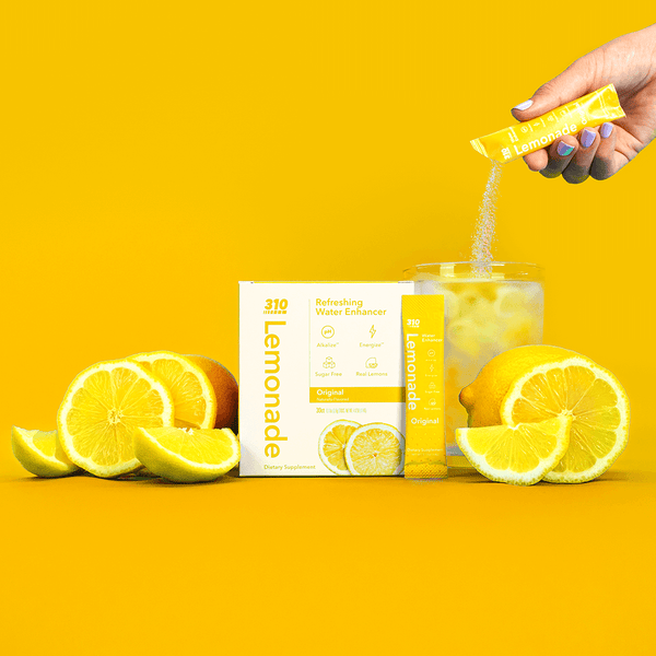 original lemonade water enhancer with fresh lemons on a vibrant yellow background