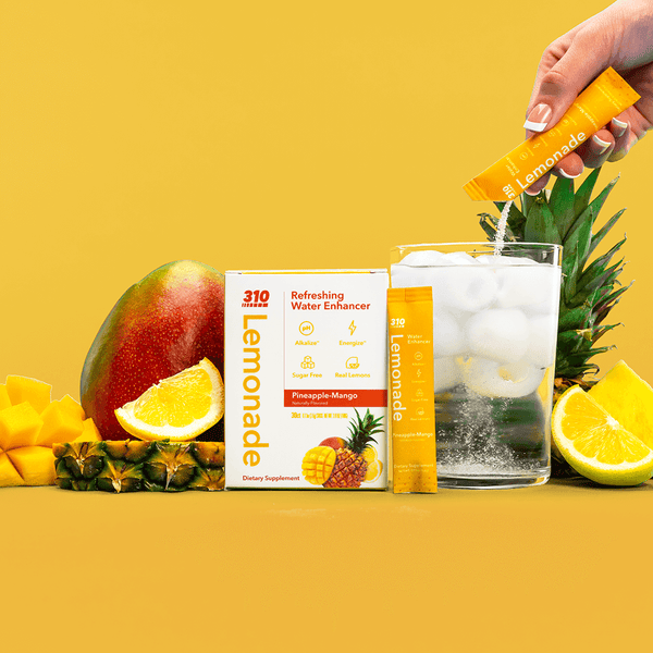 310 lemonade pineapple-mango with a glass of water and fresh fruits