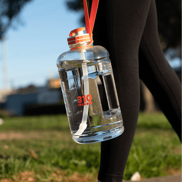 a woman in workout attire bringing the clear mega hydration bottle