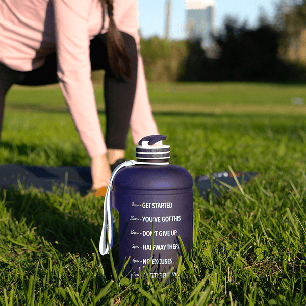 woman on a yoga mat and a mega hydration bottle on the side