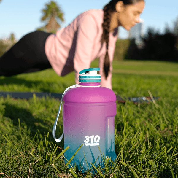 a woman doing plank and a purple/turquoise mega hydration bottle