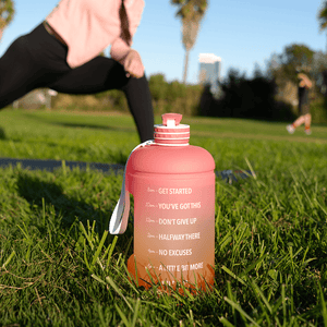 sunset mega hydration bottle and a woman on her yoga mat