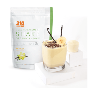 organic vegan vanilla meal replacement shake with a glass of vanilla shake
