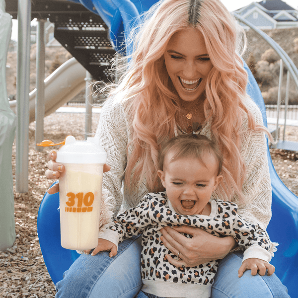 a child and a woman holding a clear shaker cup